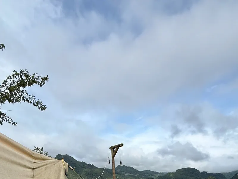 A canvas tent on a wooden deck at A Lành Camping, looking down over Meo Vac town