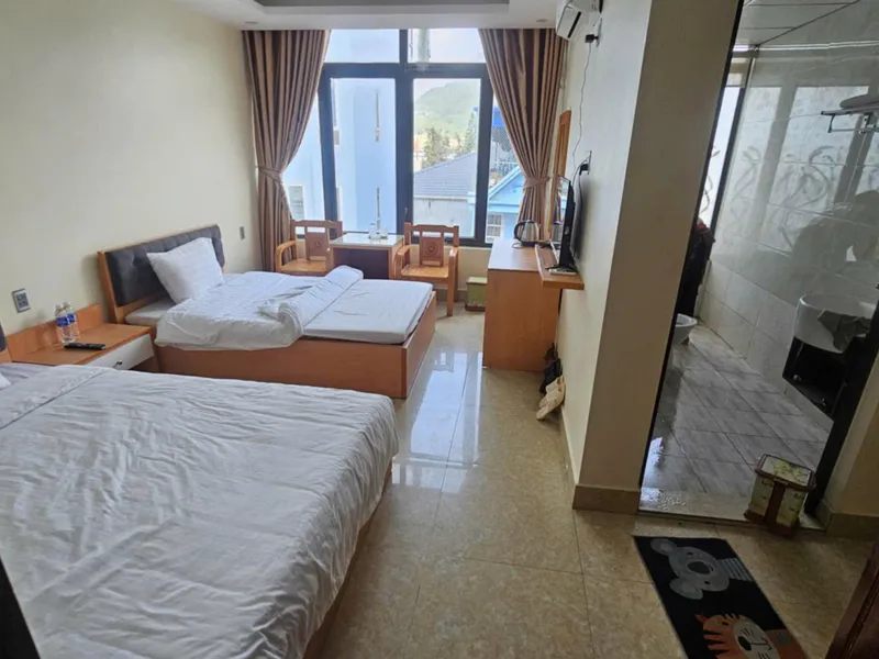 A twin room at Bao Minh Hotel in Dong Van with a window looking over the rooftops