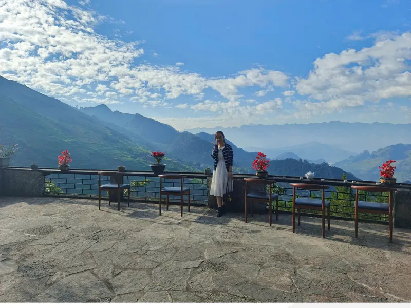 The terrace at Thẩm Mã Retreat in Yen Minh, stone floor and mountain views over the tea-plant railing