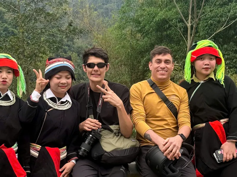 Matt and a traveller with three Dao women in traditional dress, on the road between Ha Giang and Cao Bang